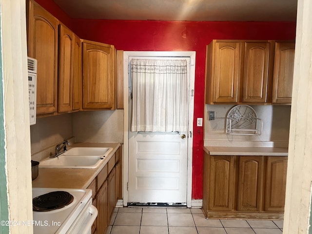 kitchen with sink, light tile patterned floors, and white electric range