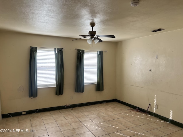 tiled spare room featuring ceiling fan and a textured ceiling