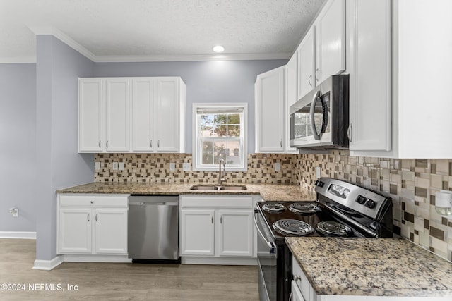 kitchen featuring white cabinets, light stone counters, sink, and appliances with stainless steel finishes