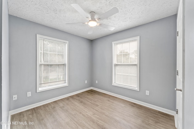 empty room featuring a textured ceiling, light hardwood / wood-style floors, and ceiling fan