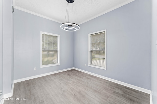 unfurnished room with a chandelier, wood-type flooring, a textured ceiling, and crown molding