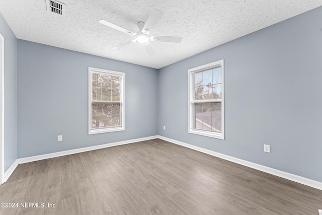 empty room featuring hardwood / wood-style floors, ceiling fan, and a textured ceiling