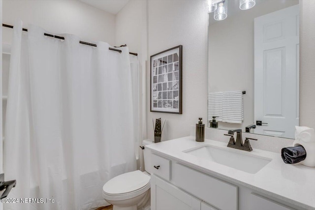 full bathroom featuring shower / tub combo with curtain, vanity, and toilet