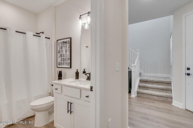 full bathroom with shower / bath combination with curtain, vanity, hardwood / wood-style flooring, and toilet