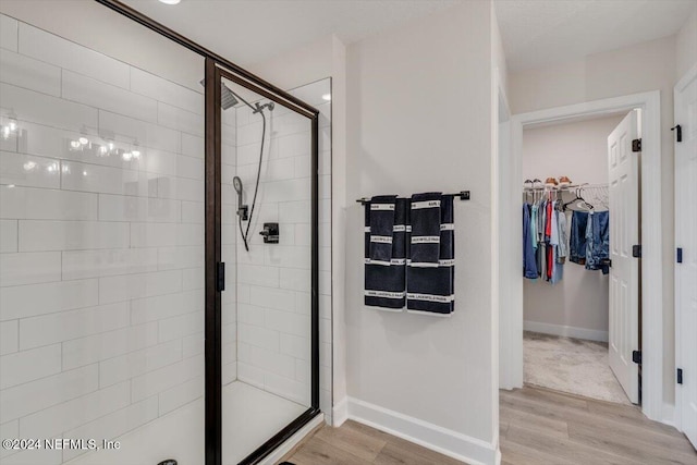 bathroom with hardwood / wood-style floors and walk in shower