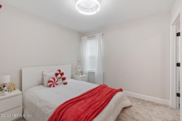 bedroom with carpet floors and a textured ceiling