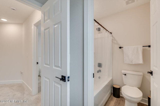 bathroom with shower / tub combo with curtain and toilet