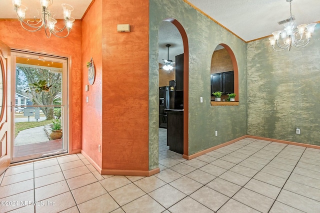 entryway with light tile patterned floors, ceiling fan with notable chandelier, and ornamental molding