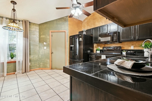 kitchen featuring black appliances, sink, vaulted ceiling, light tile patterned floors, and dark brown cabinetry