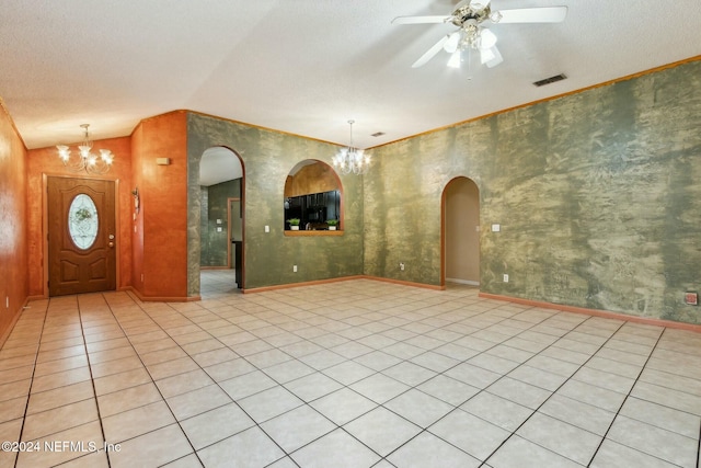 tiled entryway featuring a textured ceiling, lofted ceiling, and ceiling fan with notable chandelier