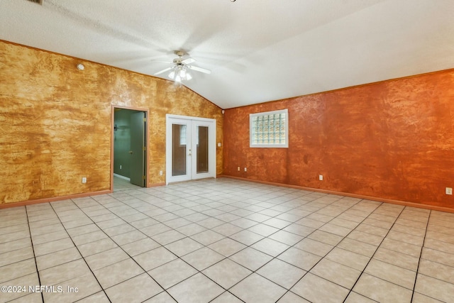 unfurnished room featuring french doors, a textured ceiling, vaulted ceiling, ceiling fan, and light tile patterned floors