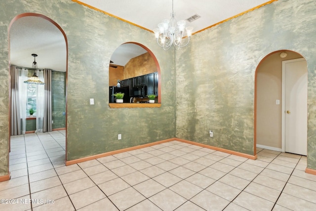 unfurnished dining area featuring a textured ceiling, light tile patterned floors, crown molding, and an inviting chandelier