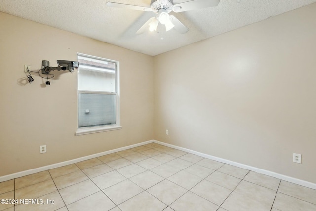 tiled spare room with ceiling fan and a textured ceiling