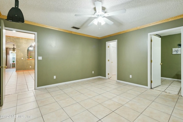 tiled spare room with a textured ceiling, ceiling fan, and crown molding