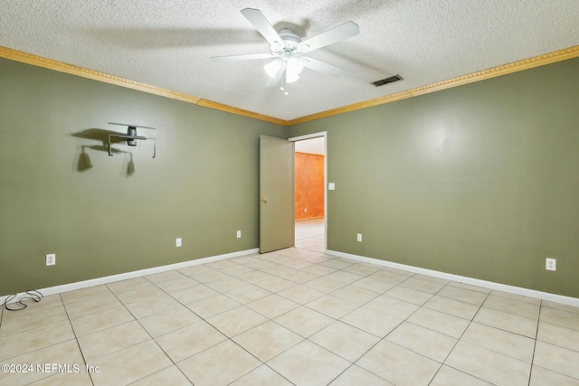 spare room with ceiling fan, light tile patterned floors, a textured ceiling, and ornamental molding