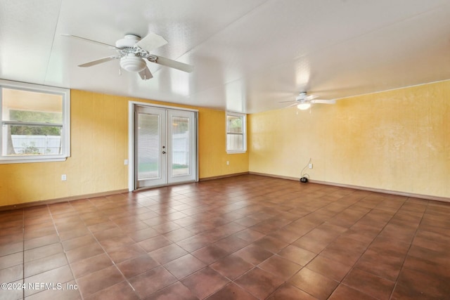 empty room featuring ceiling fan and french doors