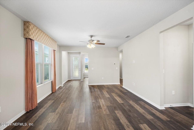 unfurnished room with a textured ceiling, ceiling fan, and dark wood-type flooring