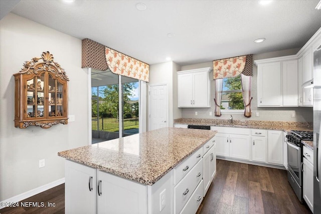 kitchen with gas stove, white cabinets, and a kitchen island