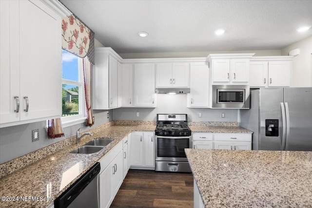 kitchen featuring white cabinetry, sink, light stone countertops, and appliances with stainless steel finishes