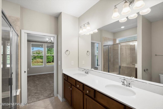 bathroom with an inviting chandelier, tile patterned flooring, an enclosed shower, toilet, and vanity