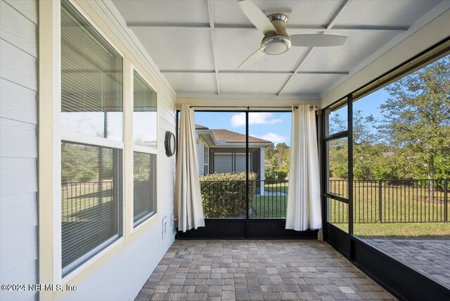 unfurnished sunroom featuring ceiling fan