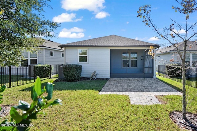 rear view of property featuring ceiling fan, a yard, and a patio