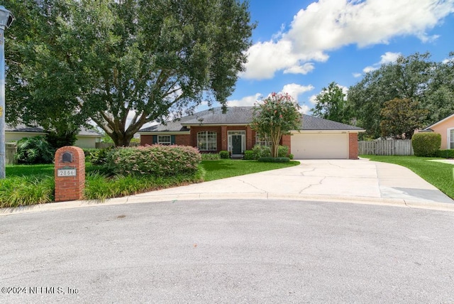 ranch-style home featuring a garage and a front lawn