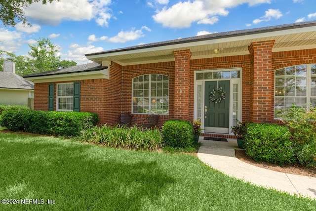 entrance to property with a lawn