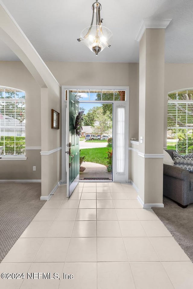 entrance foyer featuring light carpet and a chandelier