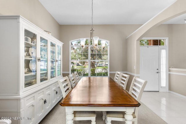 dining area with light tile patterned floors and an inviting chandelier