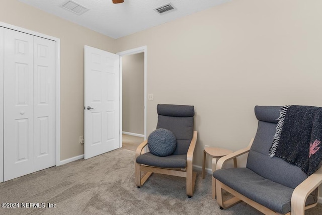 living area featuring light carpet