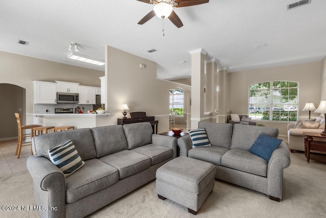 carpeted living room with ceiling fan