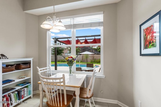 dining room with light tile patterned floors and a notable chandelier