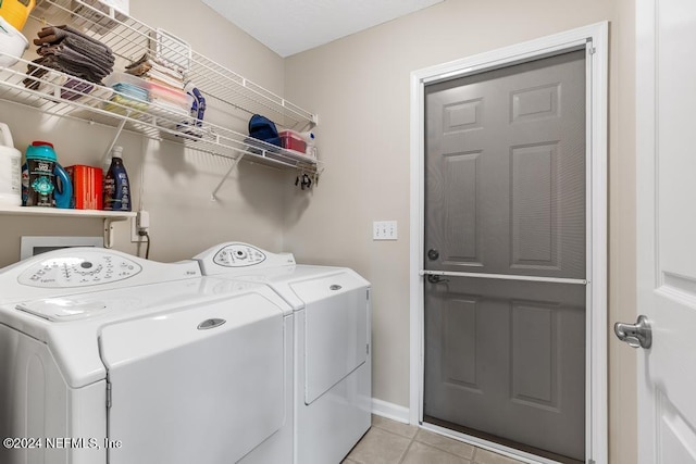 laundry room with washer and dryer and light tile patterned floors