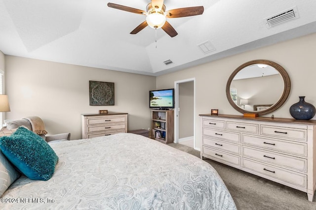 carpeted bedroom featuring ceiling fan and a raised ceiling