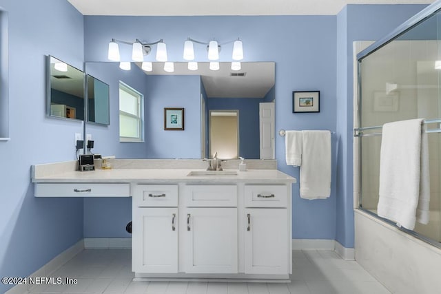 bathroom featuring combined bath / shower with glass door, vanity, and tile patterned floors