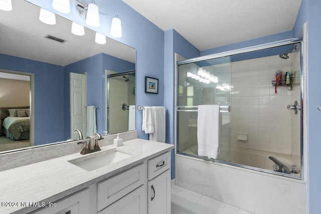 bathroom featuring vanity, a textured ceiling, tile patterned flooring, and bath / shower combo with glass door