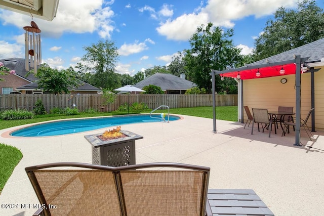 view of pool with a patio area, a yard, and an outdoor fire pit