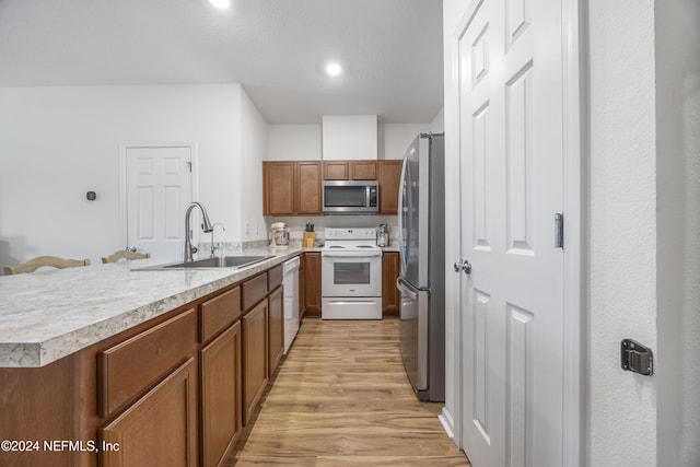 kitchen featuring stainless steel appliances, light hardwood / wood-style flooring, and sink