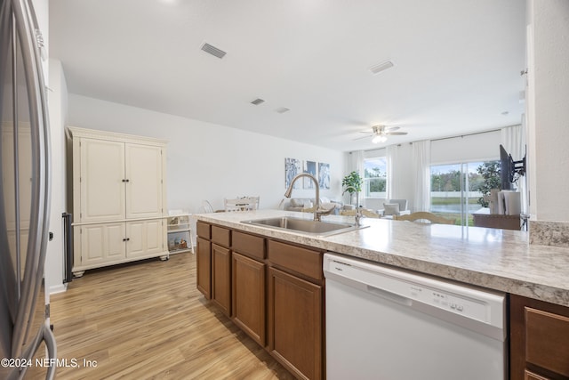 kitchen featuring white dishwasher, ceiling fan, sink, light hardwood / wood-style floors, and stainless steel refrigerator