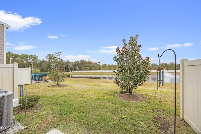 view of yard featuring central AC and a water view