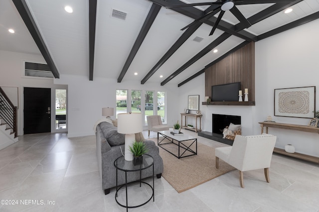 living room featuring a fireplace, lofted ceiling with beams, and ceiling fan