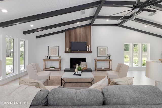 living room featuring ceiling fan, a large fireplace, beamed ceiling, and light tile patterned flooring