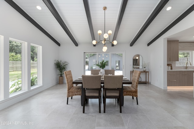 dining room featuring lofted ceiling with beams, an inviting chandelier, and sink