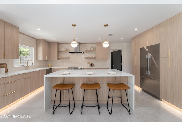 kitchen with a center island, stainless steel built in fridge, backsplash, and light brown cabinets