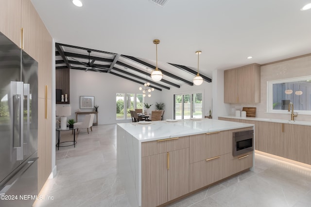 kitchen with stainless steel refrigerator, built in microwave, sink, lofted ceiling with beams, and a kitchen island