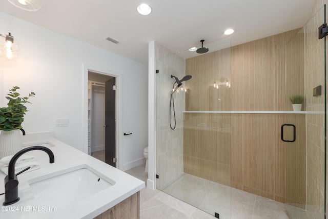 bathroom with tile patterned flooring, vanity, toilet, and walk in shower