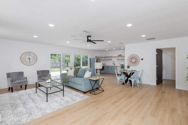 living room featuring light wood-type flooring and ceiling fan