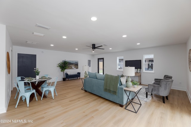 living room featuring ceiling fan, plenty of natural light, and light hardwood / wood-style floors