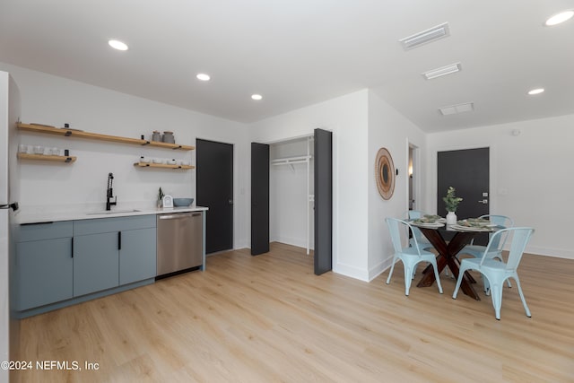 kitchen featuring dishwasher, sink, and light hardwood / wood-style flooring